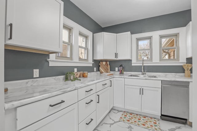 kitchen with stainless steel dishwasher, light stone counters, white cabinets, and sink