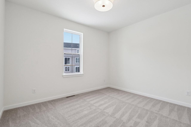 unfurnished room featuring light colored carpet