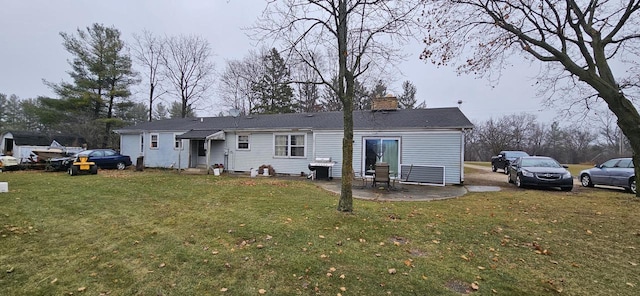 rear view of property featuring a lawn