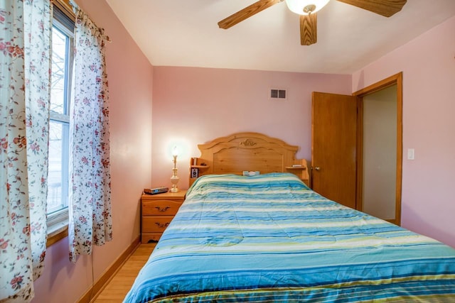 bedroom with light hardwood / wood-style floors and ceiling fan