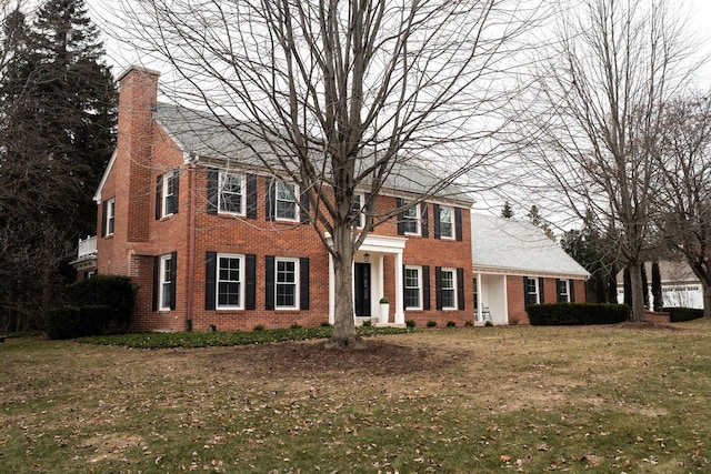 colonial-style house featuring a front lawn