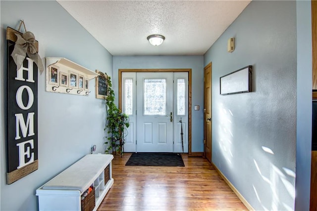 foyer entrance featuring wood-type flooring and a textured ceiling