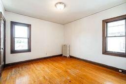 spare room with wood-type flooring and radiator