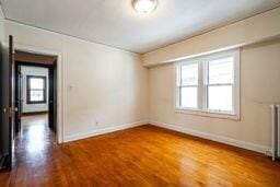 empty room featuring hardwood / wood-style flooring and radiator