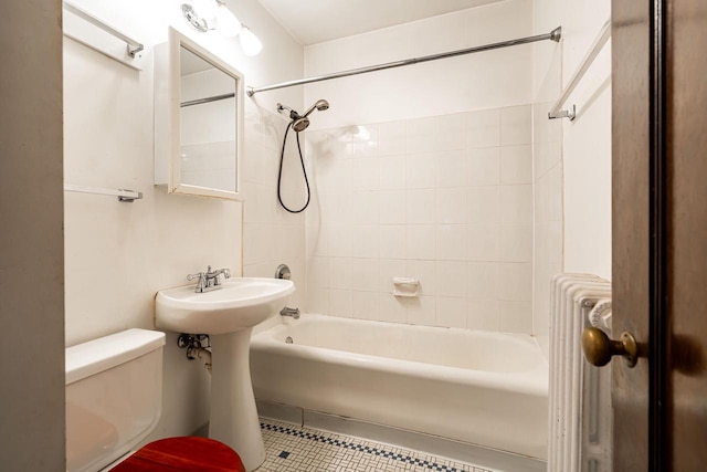 full bathroom featuring sink, radiator heating unit, tiled shower / bath combo, tile patterned floors, and toilet