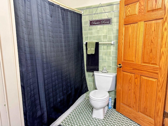 bathroom featuring a shower with curtain, toilet, and tile walls