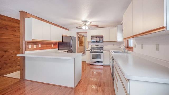 kitchen with white cabinetry, sink, light hardwood / wood-style flooring, kitchen peninsula, and black appliances