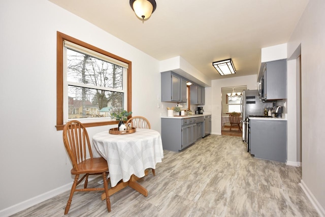 dining space with sink, a wealth of natural light, and light hardwood / wood-style flooring