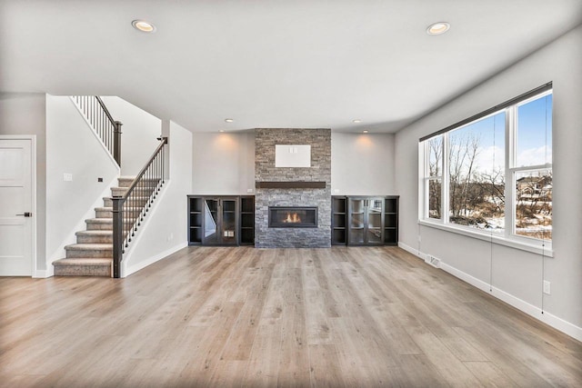 unfurnished living room featuring light wood-type flooring and a fireplace