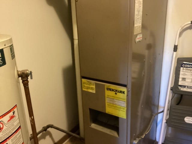 utility room with heating unit and water heater