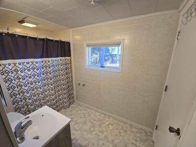 bathroom with curtained shower, vanity, and ornamental molding