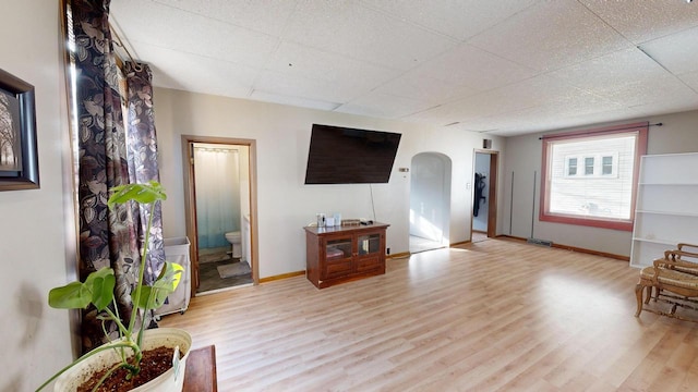 living room featuring a drop ceiling and light hardwood / wood-style flooring