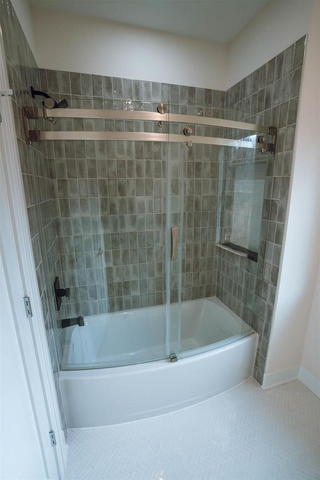 bathroom featuring combined bath / shower with glass door and tile patterned flooring