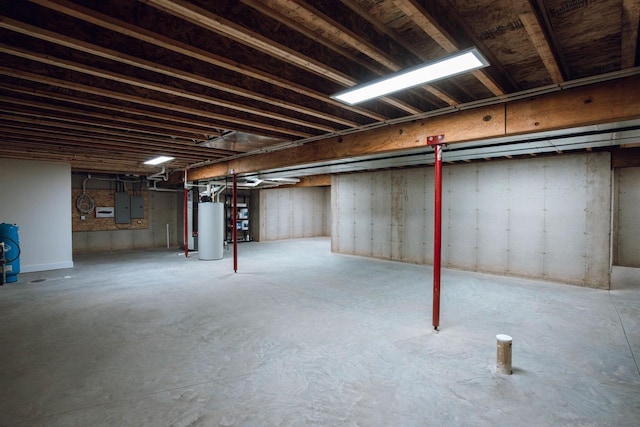 basement featuring electric panel and water heater