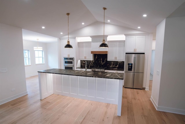 kitchen with white cabinets, dark stone counters, lofted ceiling, and appliances with stainless steel finishes