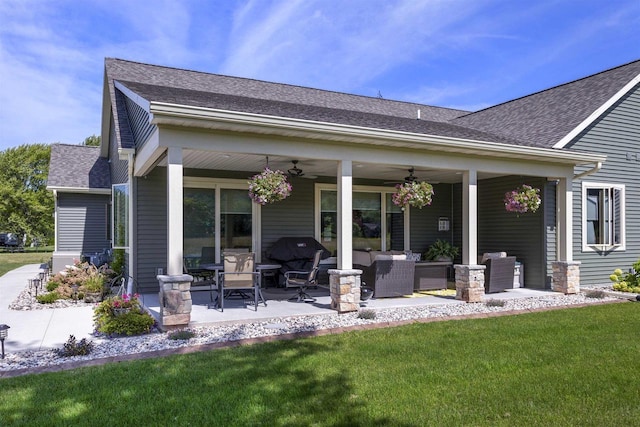 back of property with outdoor lounge area, ceiling fan, a patio area, and a lawn