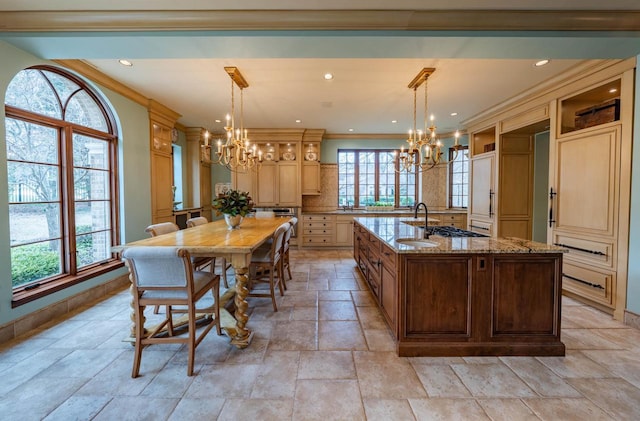 304 Braebourne Ct, Green Bay, WI 54301 - kitchen featuring a kitchen island with sink, light stone counters, decorative light fixtures, and a notable chandelier