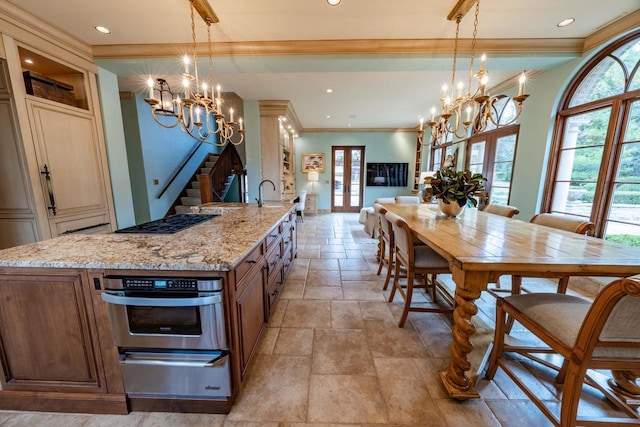 304 Braebourne Ct, Green Bay, WI 54301 - kitchen featuring a large island with sink, french doors, stainless steel oven, and hanging light fixtures