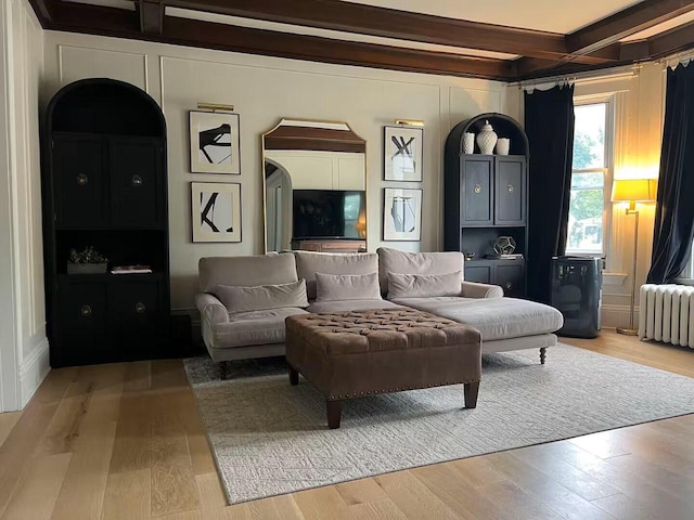 living room with beam ceiling, radiator heating unit, and hardwood / wood-style flooring