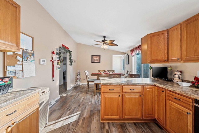 kitchen featuring ceiling fan, kitchen peninsula, dark wood-type flooring, and vaulted ceiling