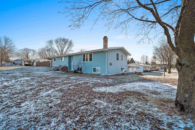 snow covered rear of property with central air condition unit