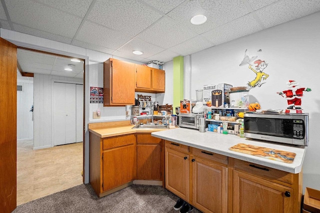 kitchen featuring a drop ceiling and sink