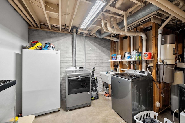 laundry area with washer and dryer, sink, and brick wall