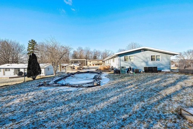 view of yard with central AC unit and a covered pool