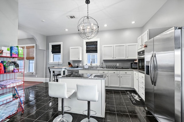 kitchen featuring white cabinetry, a center island, an inviting chandelier, decorative light fixtures, and appliances with stainless steel finishes