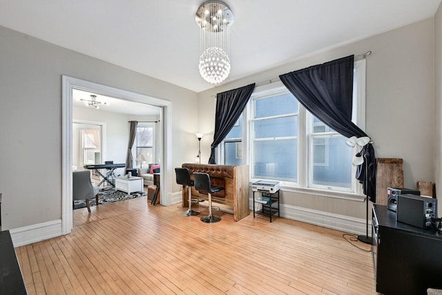 office space featuring light hardwood / wood-style flooring, an inviting chandelier, and plenty of natural light