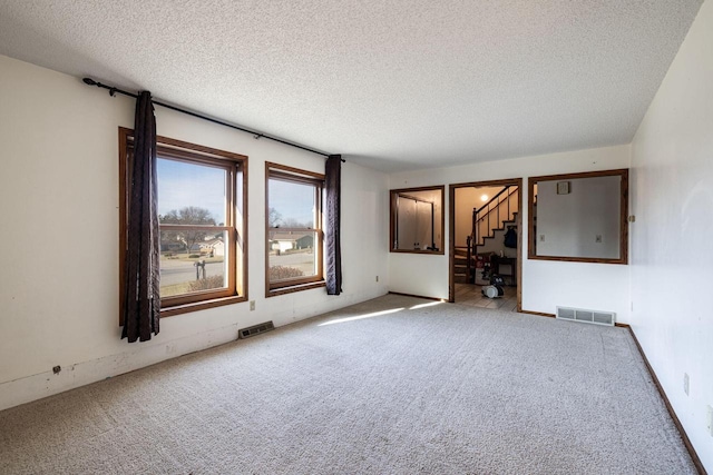 empty room with carpet and a textured ceiling