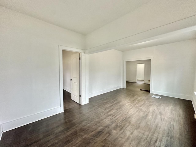 spare room featuring dark wood-type flooring