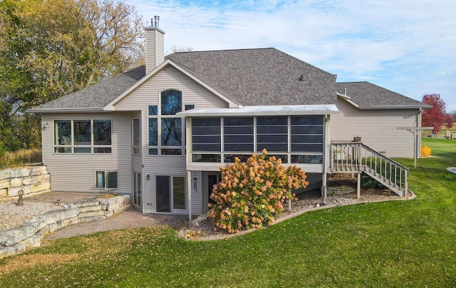 rear view of house featuring a sunroom and a yard