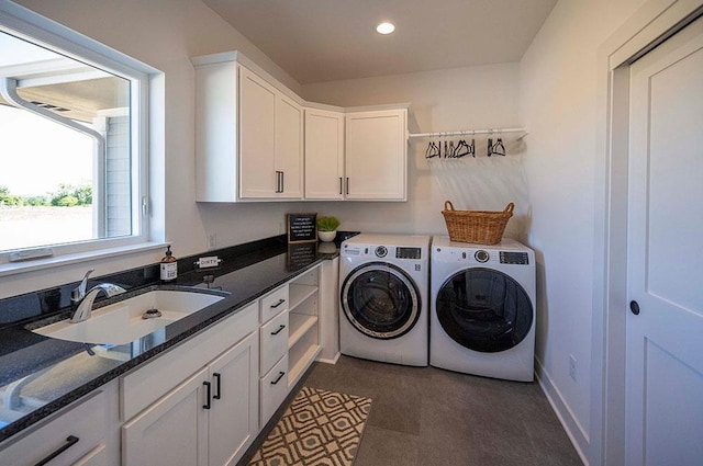 clothes washing area with cabinets, sink, and washing machine and clothes dryer