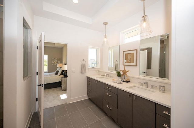 bathroom with vanity, a tray ceiling, tile patterned floors, and a wealth of natural light