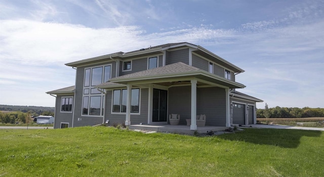 back of house with a yard and a garage