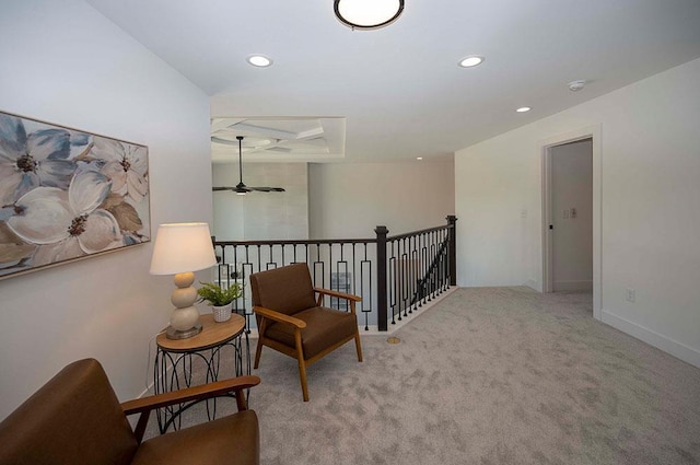 sitting room with ceiling fan and light carpet