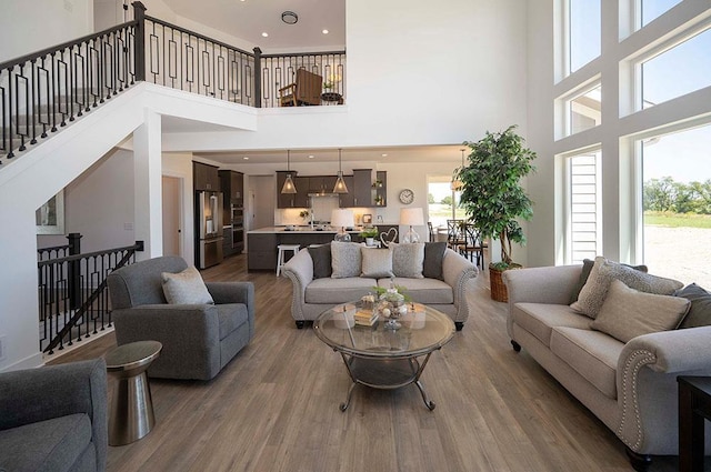 living room with hardwood / wood-style floors and a towering ceiling