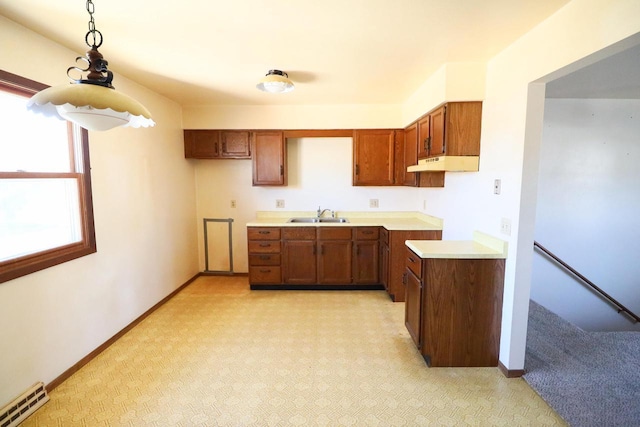 kitchen with baseboard heating, sink, and decorative light fixtures