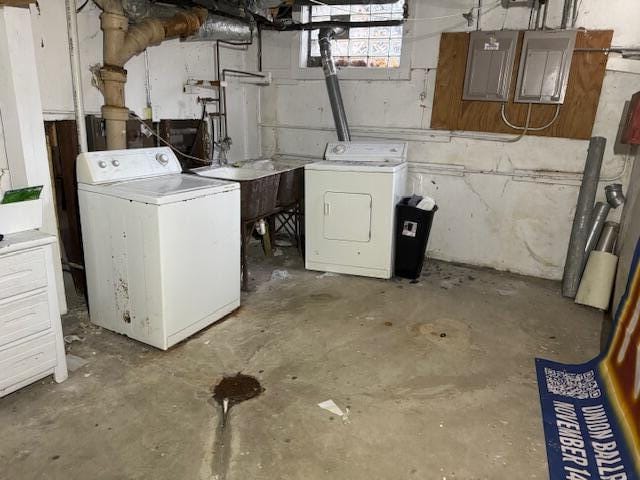 laundry area with sink, electric panel, and washing machine and clothes dryer