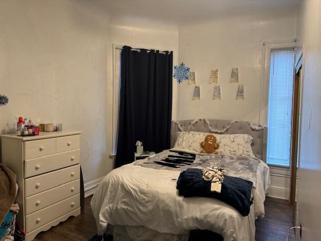 bedroom with dark wood-type flooring