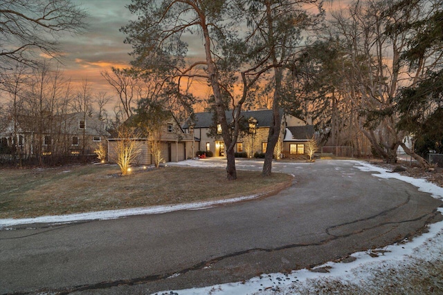 view of front of property with a garage and a lawn