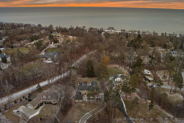 aerial view at dusk featuring a water view