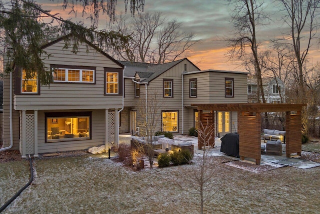 back house at dusk with an outdoor living space and a patio area