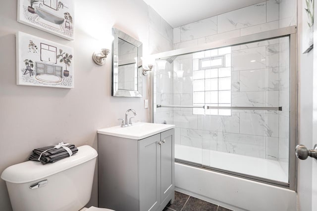 full bathroom featuring tile patterned flooring, vanity, toilet, and shower / bath combination with glass door