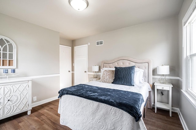 bedroom featuring dark hardwood / wood-style floors and multiple windows