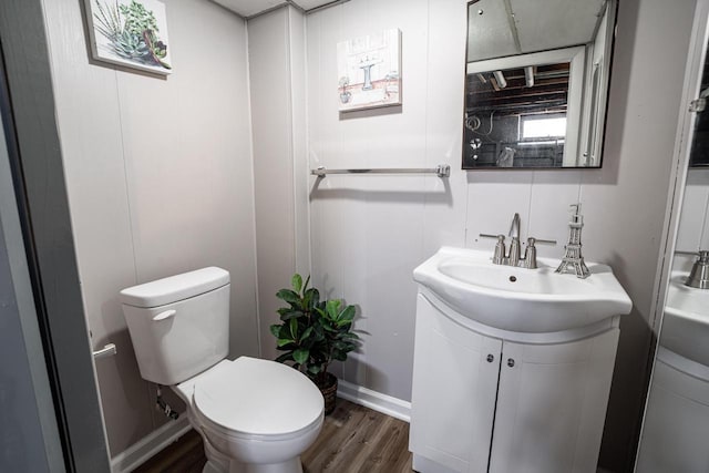 bathroom with wood-type flooring, vanity, and toilet