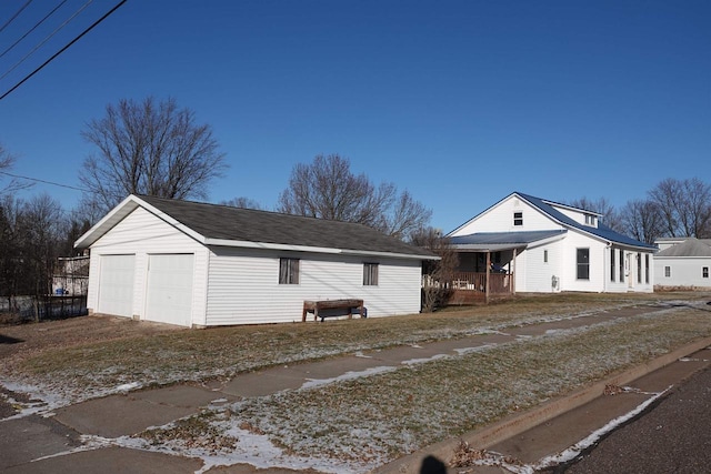 view of front of house featuring a garage and an outbuilding