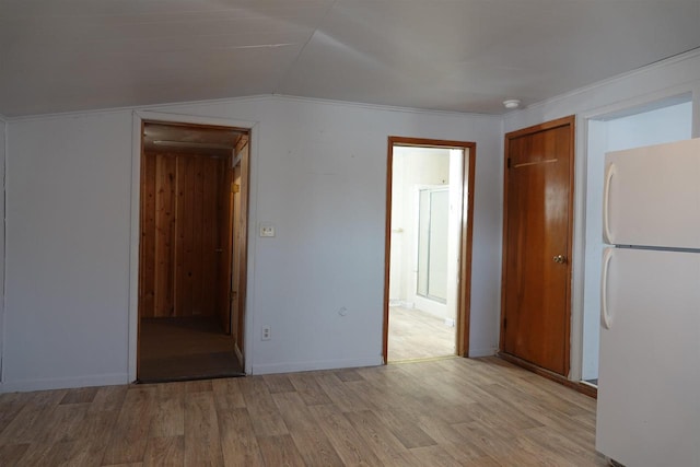 spare room with vaulted ceiling and light wood-type flooring