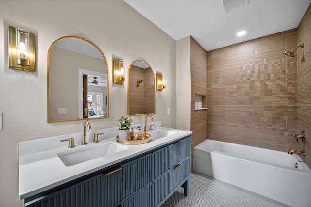 bathroom featuring tile patterned floors, ceiling fan, vanity, and tiled shower / bath